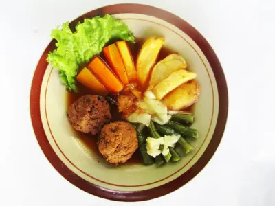 Seporsi Selat Solo lengkap dengan daging bistik, telur bumbu, kentang goreng, buncis, wortel, daun selada, dan kuah segar.