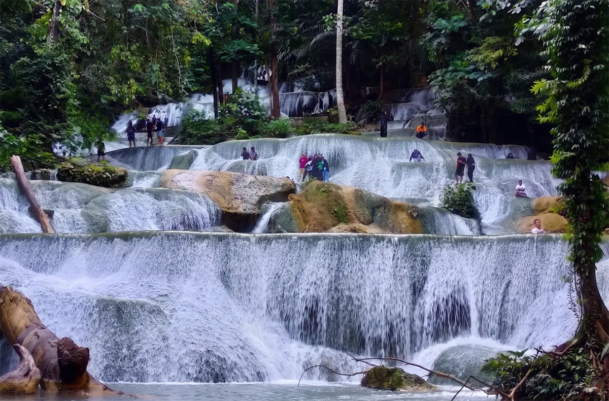 Pesona 67 Undakan Batuan Kapur Air Terjun Moramo Sulawesi Tenggara Wisatawan berdiri dan berendam di atas undakan batuan kapur bebas lumut Air Terjun Moramo Sulawesi Tenggara di tengah Hutan Suaka Alam Tanjung Peropa