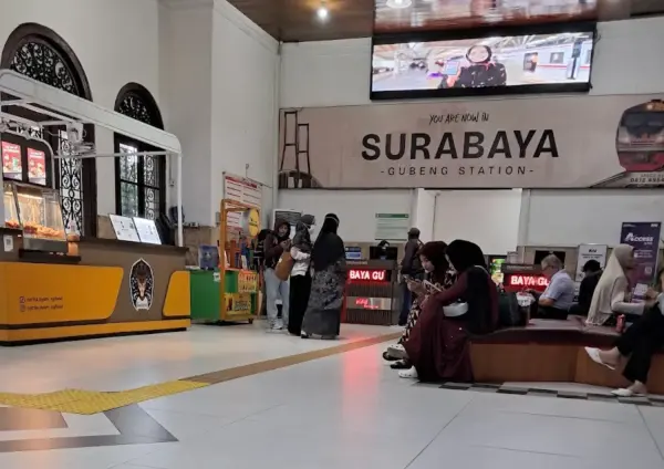 Keluarga traveler berdiri di peron Stasiun Gubeng Surabaya bersiap naik Kereta Api Probowangi menuju Banyuwangi dalam rangkaian itinerary Jakarta Bali.